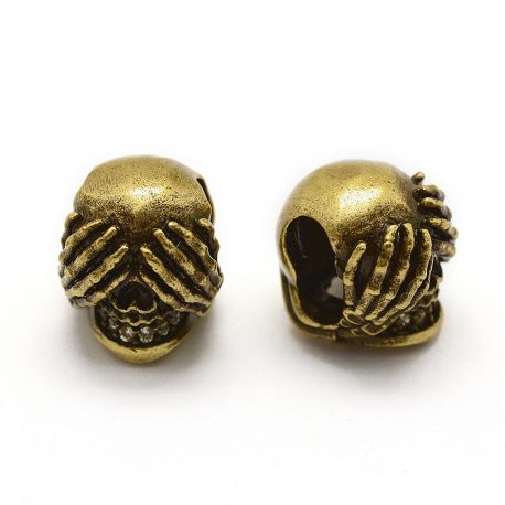 Priedai papuošalams - Žalvarinis intarpas "Kaukolė". Sendintos bronzinės spalvos vidinės skylės diametras ~6x3 mm skaidrios spal